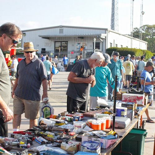 The public looks through yard sale materials as a student looks on to assist