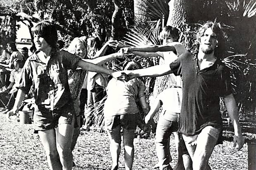 Black and white photo of students holding hands and dancing