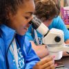 High school student looks into microscope at Eckerd pre-college program