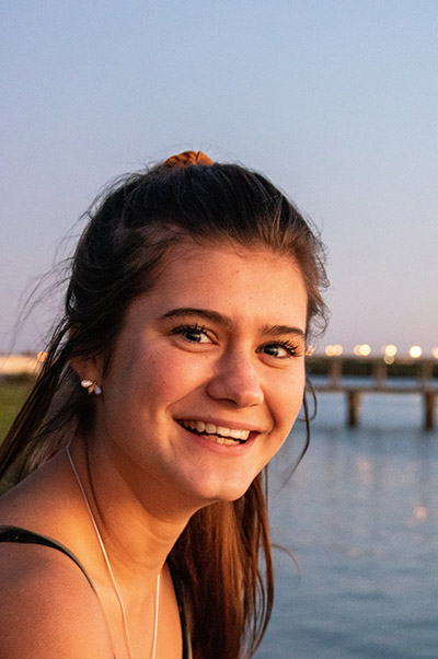 Student smiling with water behind her