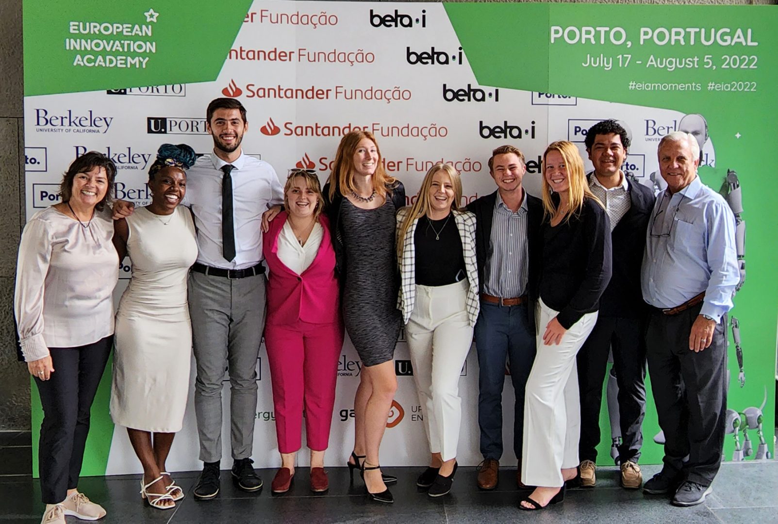 Group of Eckerd students and two professors standing side by side at conference