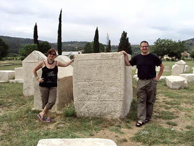 Husband and wife standing next to old stone block