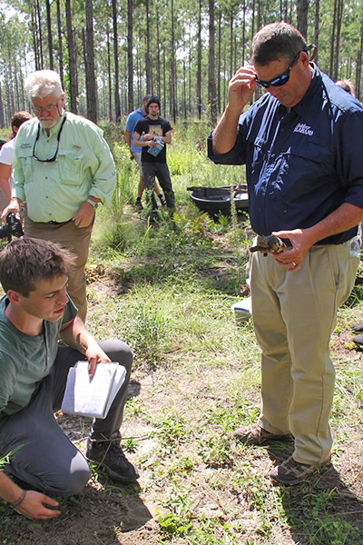 Student in the field with Alabama official