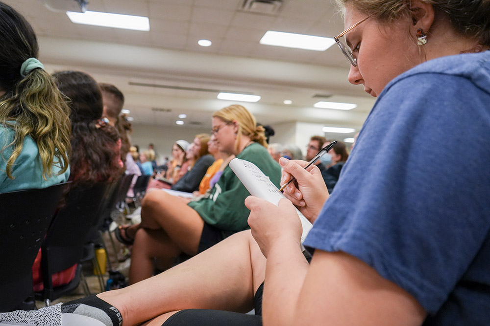 Student takes notes in a copy of the author's book