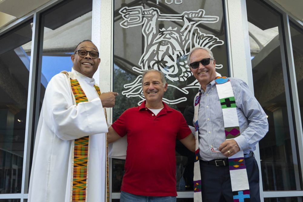 Father Stephan, Rabbi Ed, Chaplain McMahon standing side by side in front of the pub