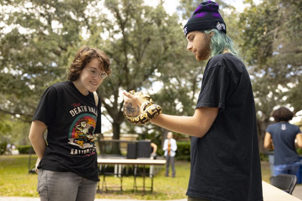 Student showing pet snake to a fellow student