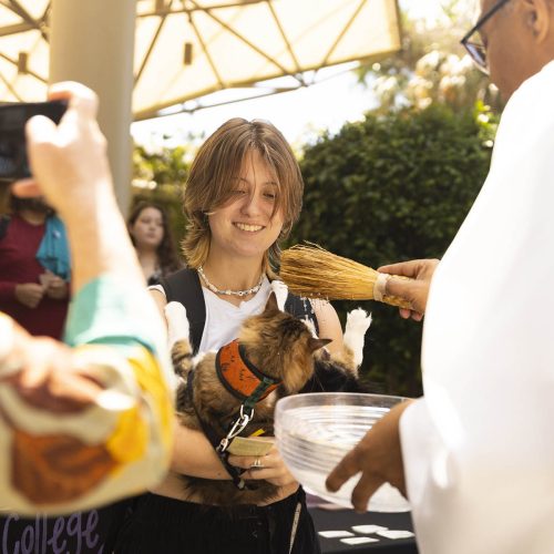 Student's pet receives a blessing from Father Stephan