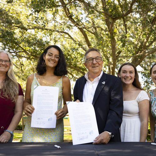 Two faculty persons, two students and the president of Eckerd College holding pledges