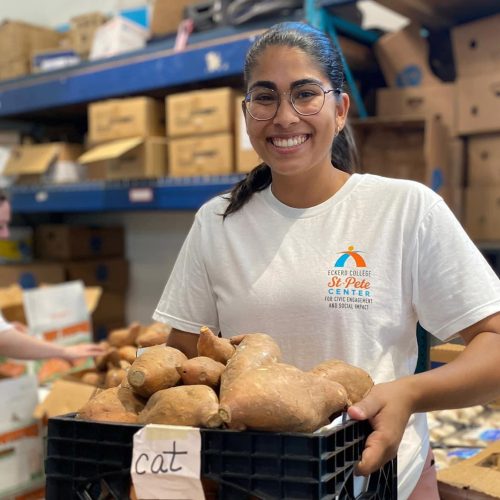 Student holds a big crate of bread