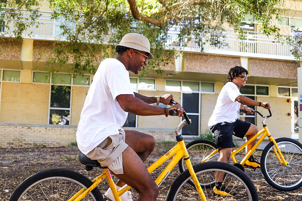 Two students riding yellow bikes