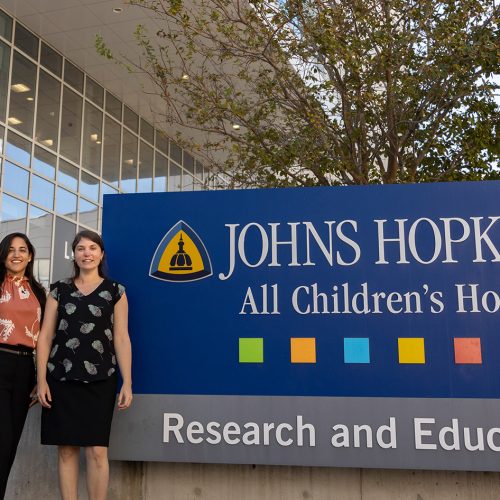 Two women standing in front of sign that reads Johns Hopkins All Children's Hospital