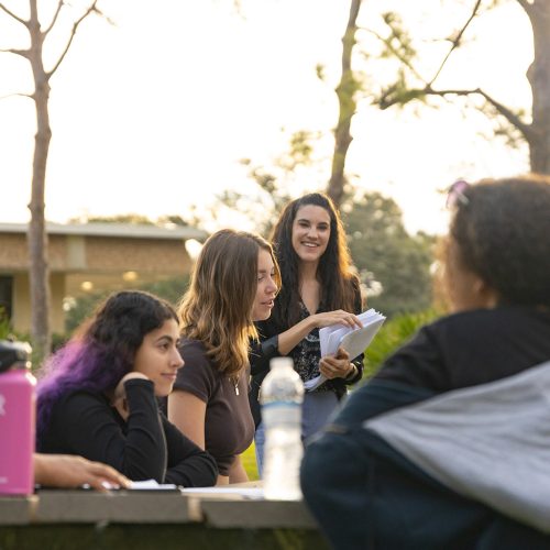 Professor teaching students outdoors