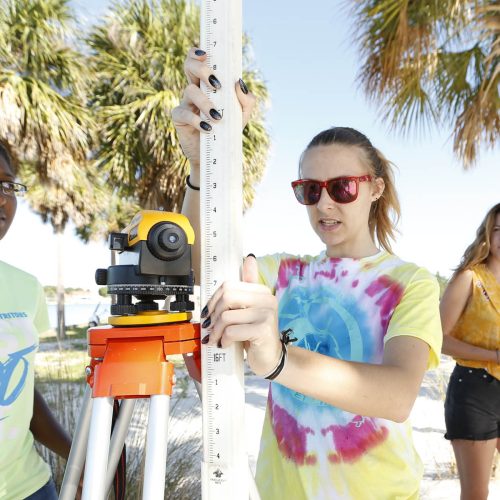 Students on beach using surveying equipment
