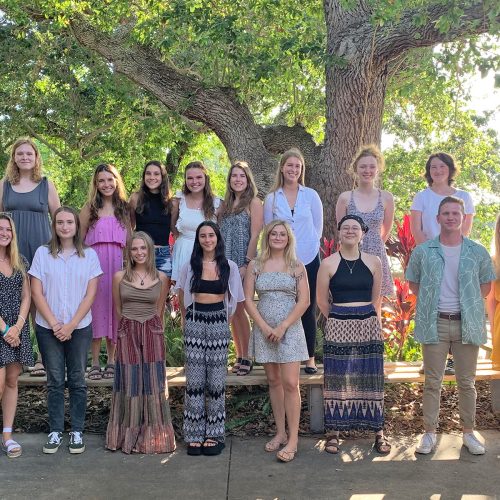 Large group of students standing on patio by pond