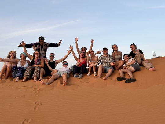 Group of students sitting on a sand dune