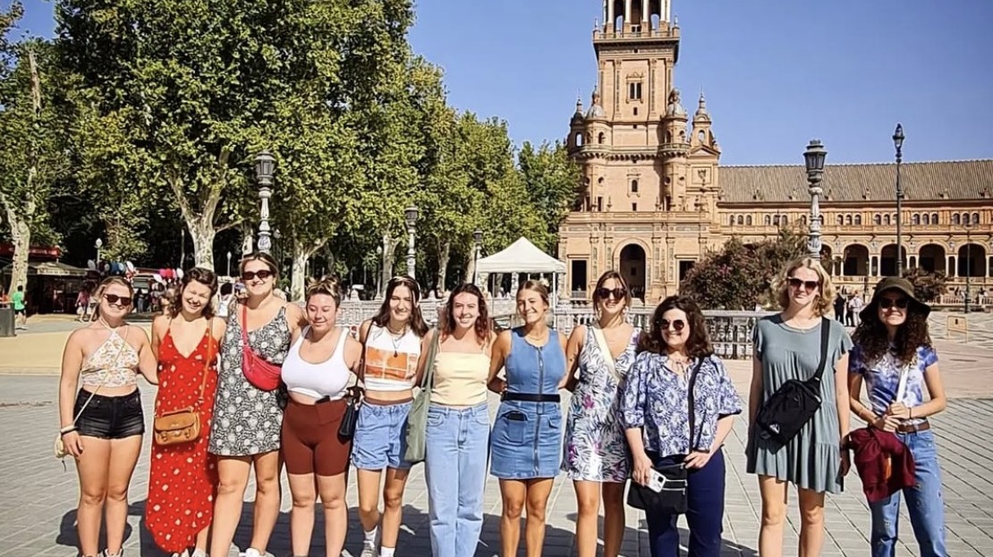 Group of students and professor standing in plaza