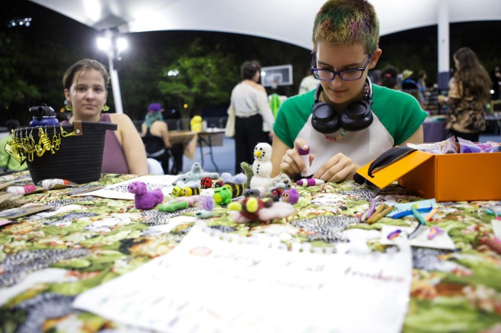 Student artist working on art at a table