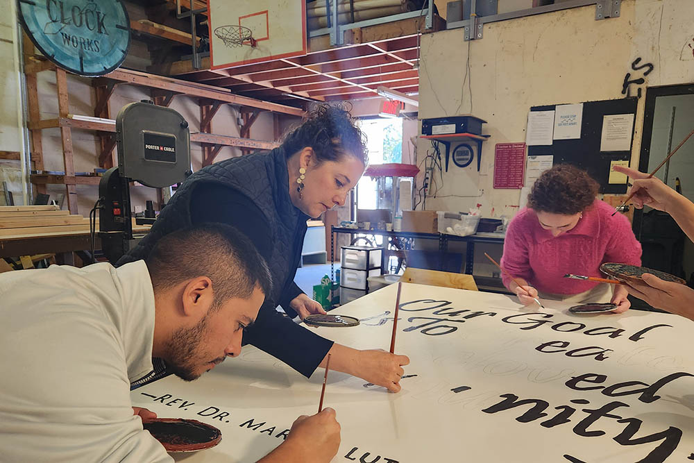 Staff painting a board in the shop