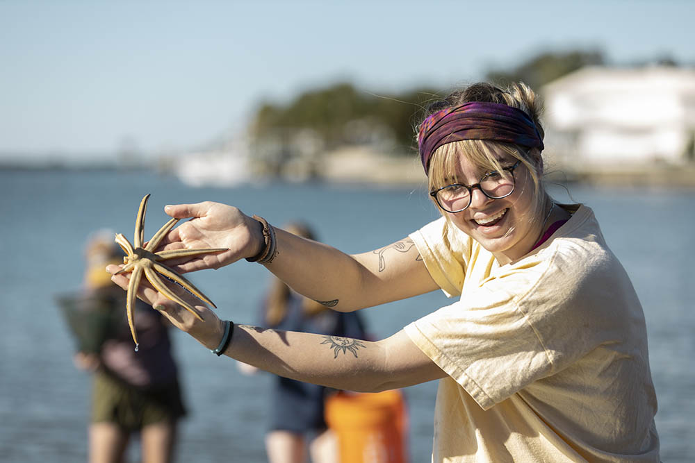 Student smiling while holding a large seastar