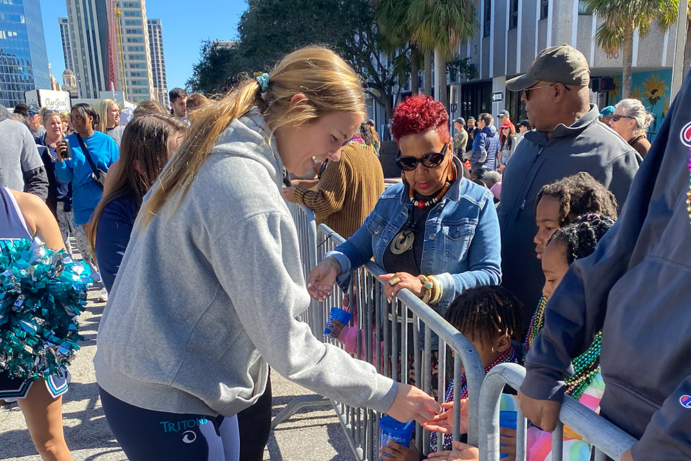 Student-athlete shares treats with parade attendees