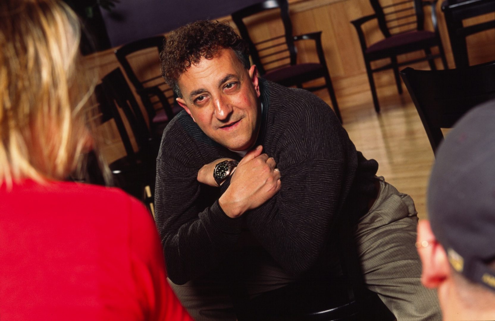 Jim Annarelli leans over a chair to speak with Eckerd College students