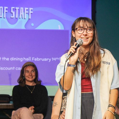 Student stands on stage with microphone