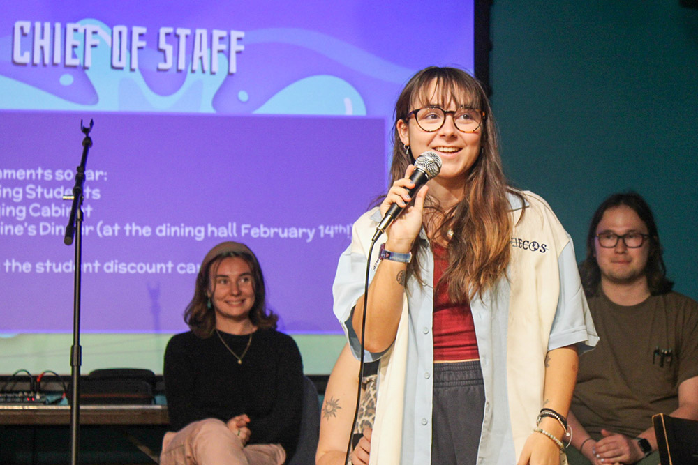 Student stands on stage with microphone