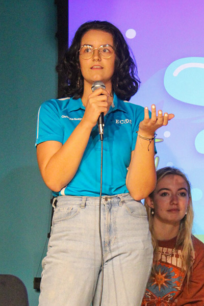 Student speaks with microphone from stage