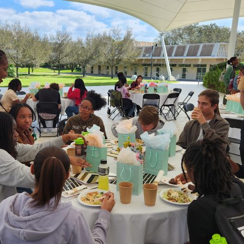 Sherman-White stands at a table of high school students