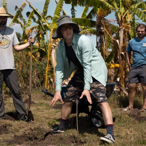 Thomas standing over newly planted tree