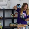 Student placing food onto a shelf