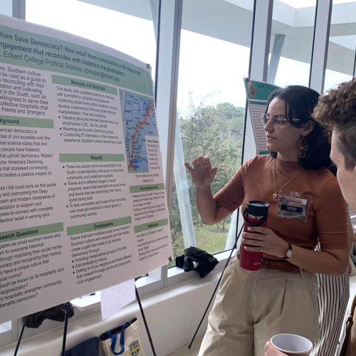 Student explains scientific poster to a visitor