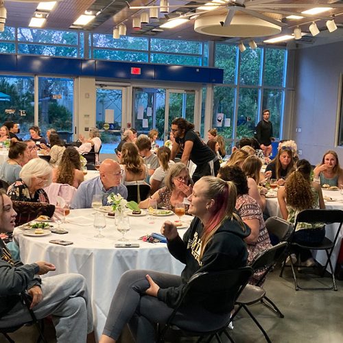 A group of people seated at tables in a hall