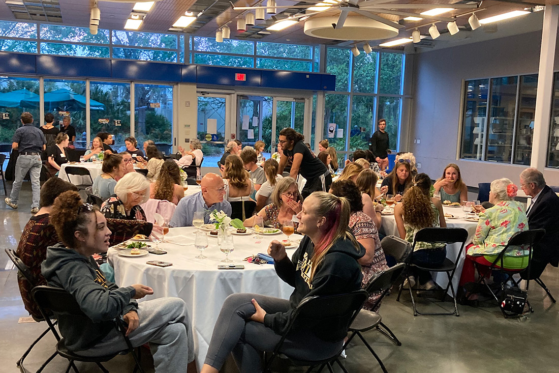A group of people seated at tables in a hall