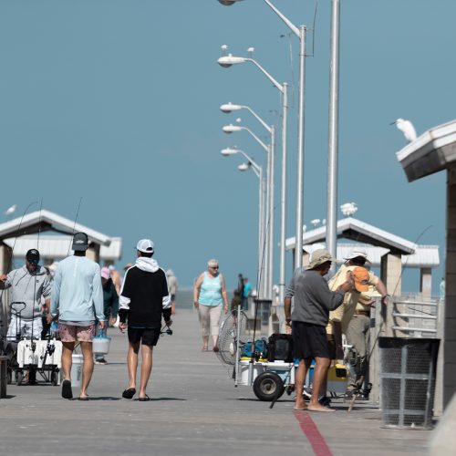 Community members walking along a fishing pier