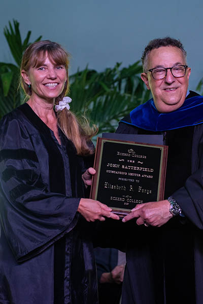 Professor and president holding plaque together