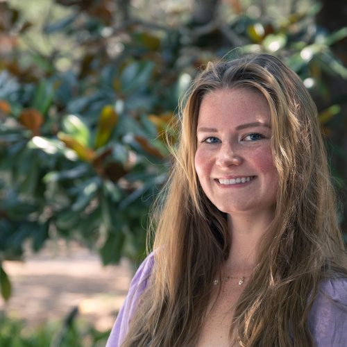 Student in long hair smiles at camera