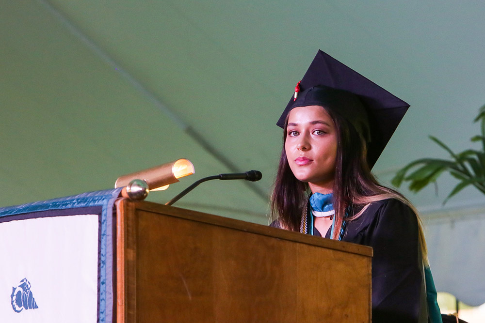 Student in graduation cap speaks at podium