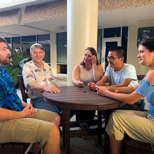 Group of students, staff, alumni around a table