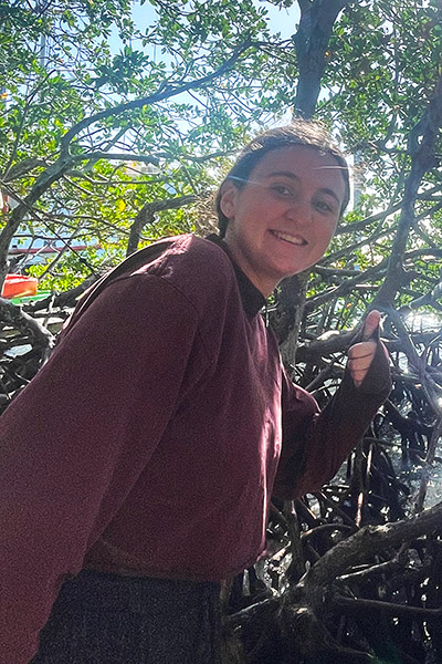Student standing in mangroves
