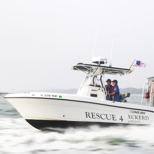 College students driving a search and rescue boat on the ocean