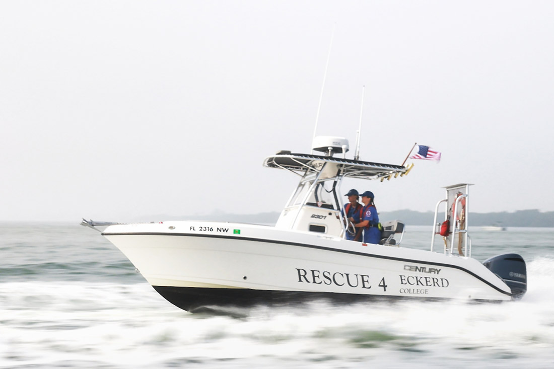 College students driving a search and rescue boat on the ocean