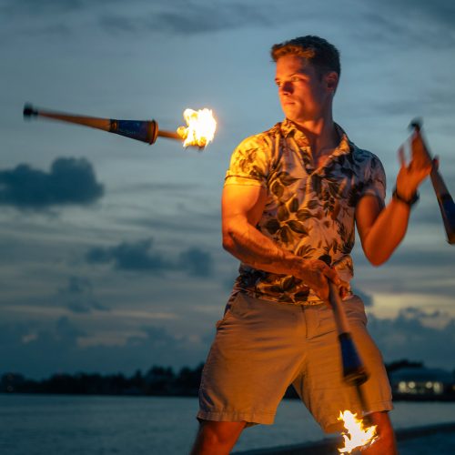 Eckerd College student on the beach juggling fire