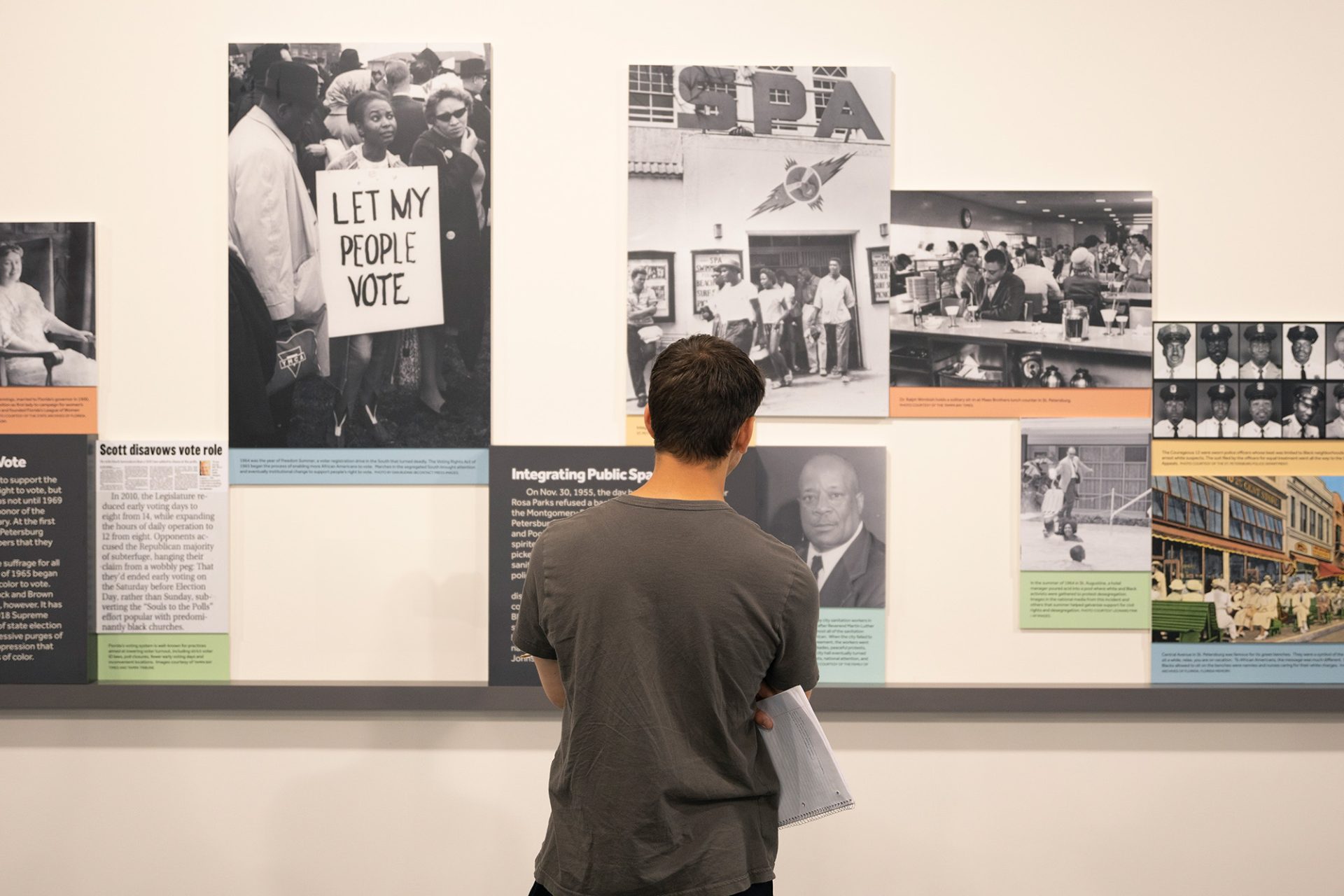 Student looks at a wall of historical images