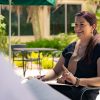 Professor smiles with students while seated outdoors in cafe setting