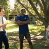 Professor chats with three students in outdoors location