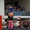 Wrestlers in a wrestling arena with spectators looking on