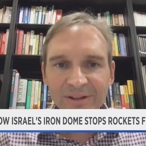 Screen from TV program showing interview of professor with text "How Israel's Iron Dome stops rockets from Hamas"