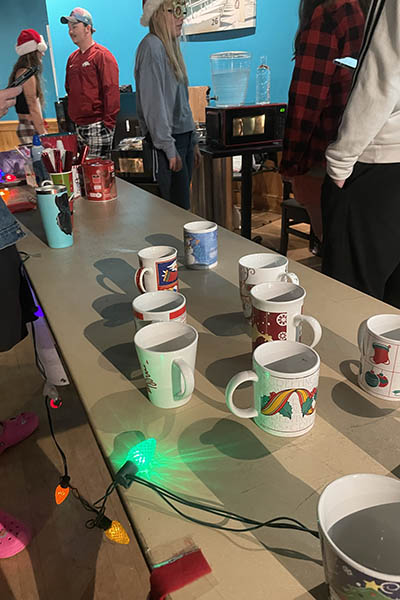 Mugs and holiday lights adorn a table in the pub