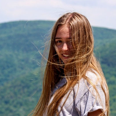 Student standing in front of distant mountains